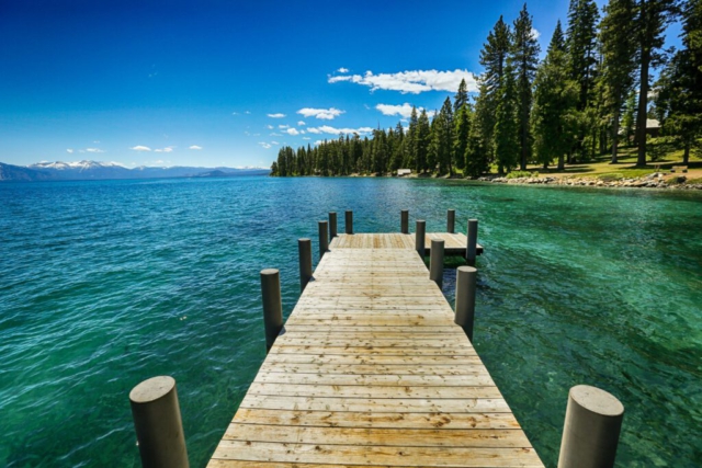 Hinter dem Lake Tahoe liegen die schneebedeckten Berge.